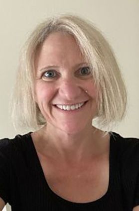 Headshot of WVU researcher Amy Gentzler. She is pictured in front of an off white background. She has light blonde hair cut in a bob and is wearing a black, scoop-neck T-shirt. 