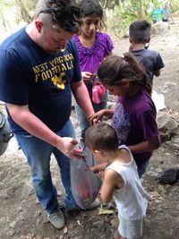 Sociology Instructor Daniel Brewster shares candy with Nicaraguan children