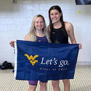 Sarah Heilman holding WVU Let's Go flag after swimming
