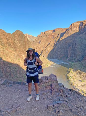 Brandon Ritter stands in front of a canyon with a river at the bottom