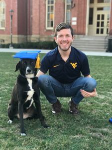 Matthew Witt with dog in front of Woodburn Hall