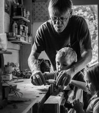 Jim Probst woodworking with two children