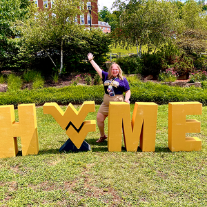 Raeanne Beckner with the WVU HOME sign