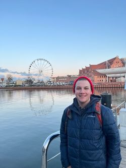 Owen McCaffrey standing outside with water and ferris wheel in the background