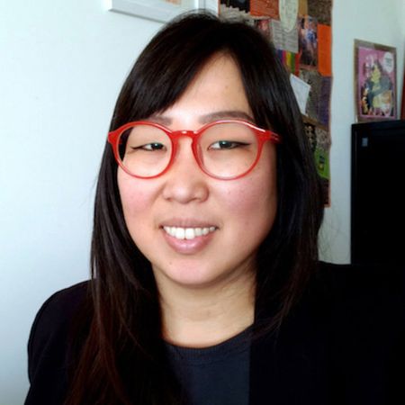Asian female with long dark hair wears red rimmed glasses