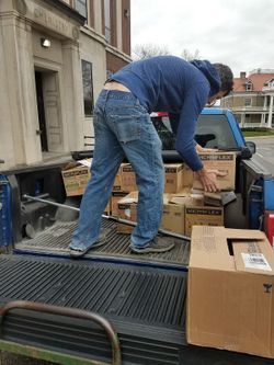 Program assistant Kevin Dixon loads boxes of personal protective equipment into a pickup truck